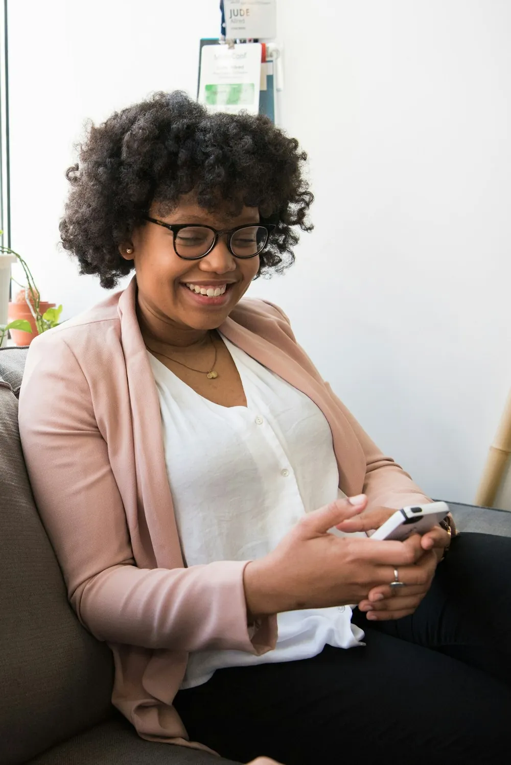 A woman smiling at her phone while she sets up a transfer